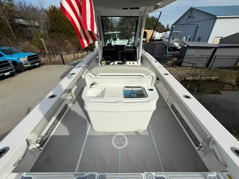 Slide: The Image of 2020 Everglades 273 Center Console boat with American flag, spacious deck, and modern amenities. - 9