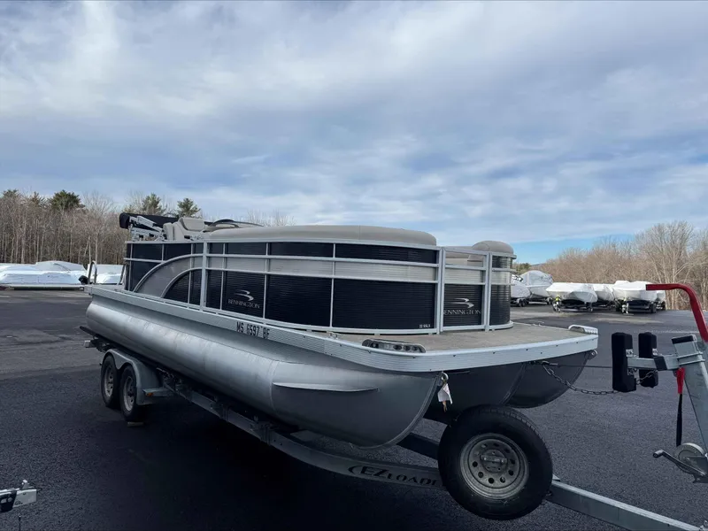 Slide: The Image of 2016 Bennington 22SLXP pontoon boat on trailer under cloudy sky. - 2