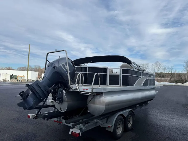 Slide: The Image of 2016 Bennington 22SLXP pontoon boat on trailer, parked outdoors under cloudy sky. - 3