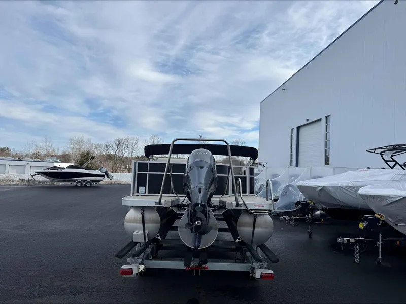 Slide: The Image of 2016 Bennington 22SLXP pontoon boat on trailer, parked near a large building. - 4