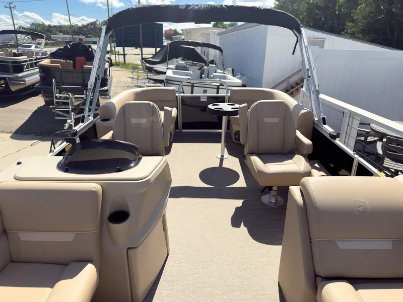 Slide: The Image of 2025 Godfrey Sweetwater Xperience 22' Tritoon with split bench seating, beige interior, and canopy. - 11