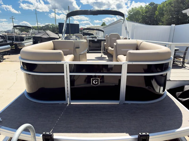 Slide: The Image of 2025 Godfrey Sweetwater Xperience 22' Tritoon with split bench seating, docked under sunny skies. - 5