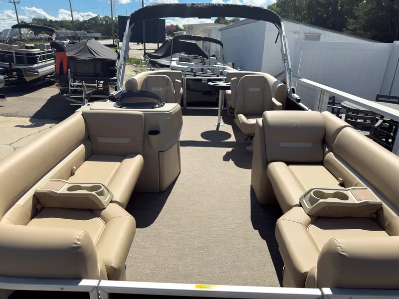 Slide: The Image of 2025 Godfrey Sweetwater Xperience 22' Tritoon with split bench seating, beige interior, and canopy. - 6