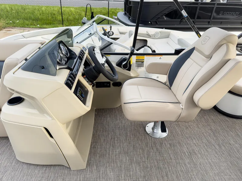 Slide: The Image of 2025 Godfrey Sweetwater 22' Flip Lounge Tritoon interior with captain's chair and steering console. - 12