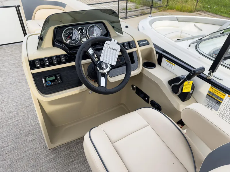 Slide: The Image of Captain's helm of 2025 Godfrey Sweetwater 22' Flip Lounge Tritoon, featuring modern controls and seating. - 13