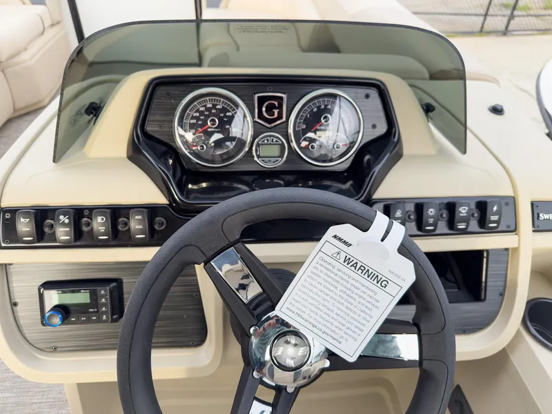 Slide: The Image of Steering console of 2025 Godfrey Sweetwater 22' Flip Lounge Tritoon with gauges and controls. - 14