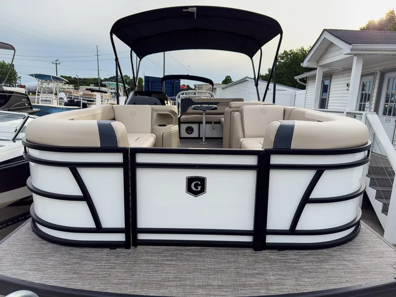 Slide: The Image of 2025 Godfrey Sweetwater 22' Flip Lounge Tritoon with canopy, docked near a marina. - 4