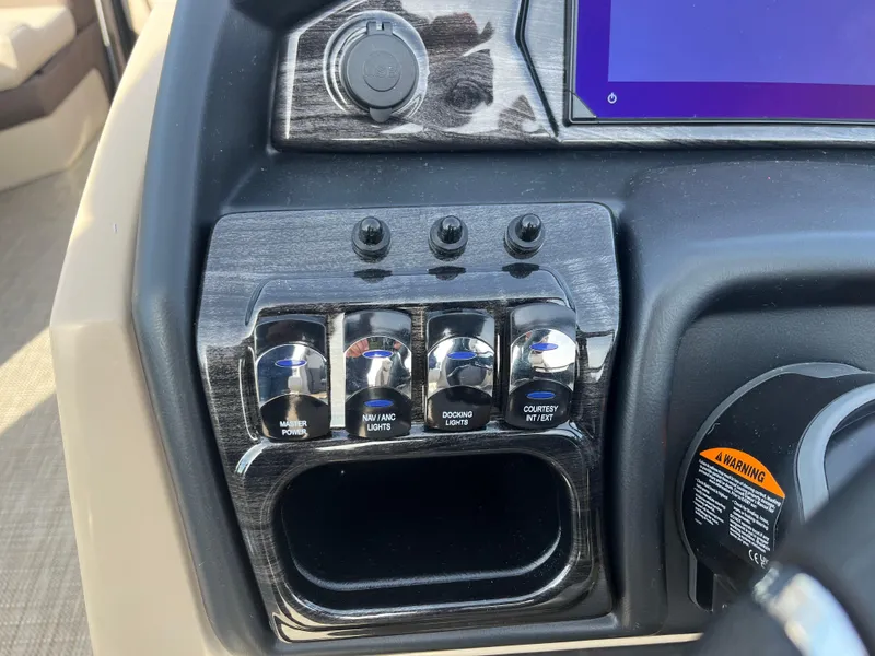 Slide: The Image of Control panel of 2025 Bentley Pontoons 223 Elite Admiral with switches and warning label. - 25