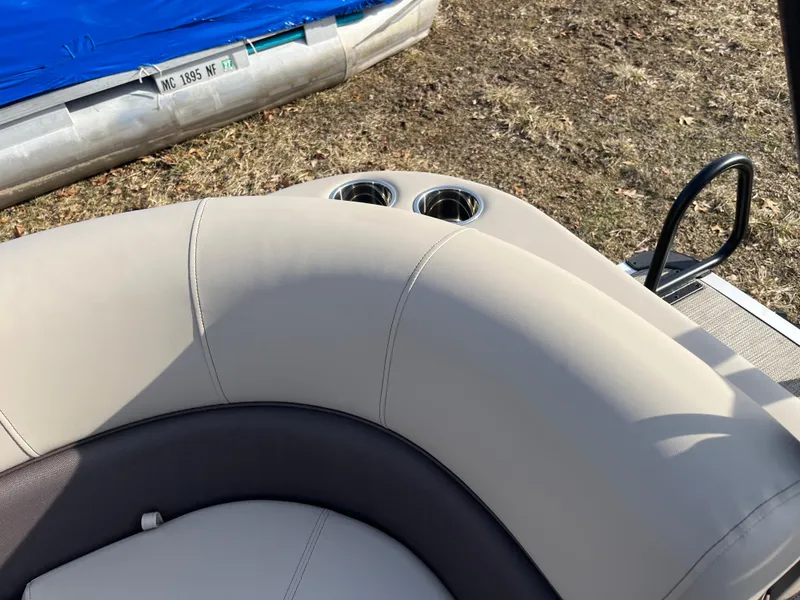 Slide: The Image of 2025 Bentley Pontoons 223 Elite Admiral, beige seating with cup holders, outdoor setting. - 28