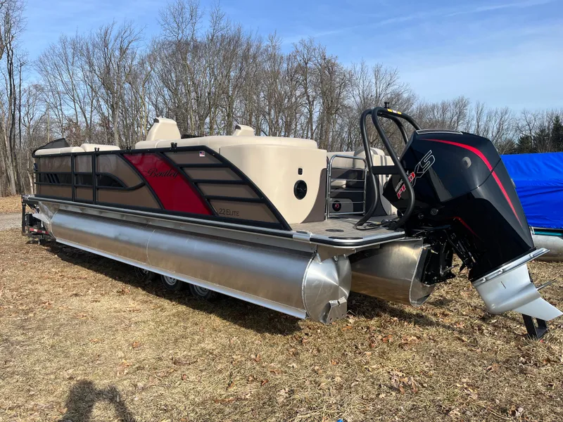 Slide: The Image of 2025 Bentley Pontoons 223 Elite Admiral on grassy field, showcasing sleek design and powerful engine. - 4
