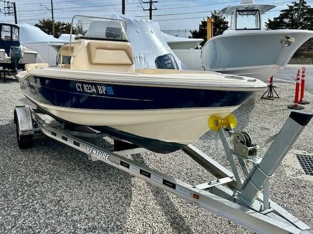 Slide: The Image of 2023 Scout 175 Sportfish boat on trailer, displayed outdoors. - 2