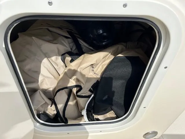 Slide: The Image of Storage compartment of 2023 Scout 175 Sportfish boat with beige and black fabric inside. - 7