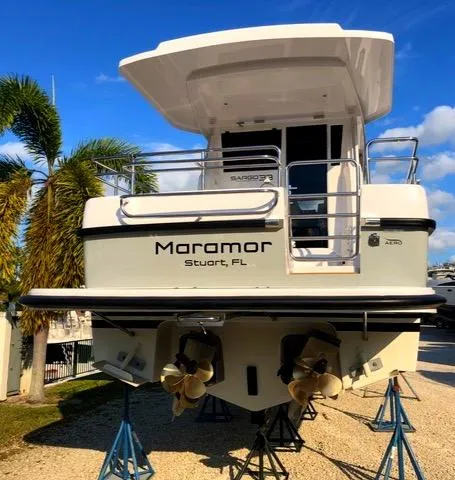 Slide: The Image of 2019 Sargo 33 All Season boat on stands, rear view, with palm trees in background. - 8