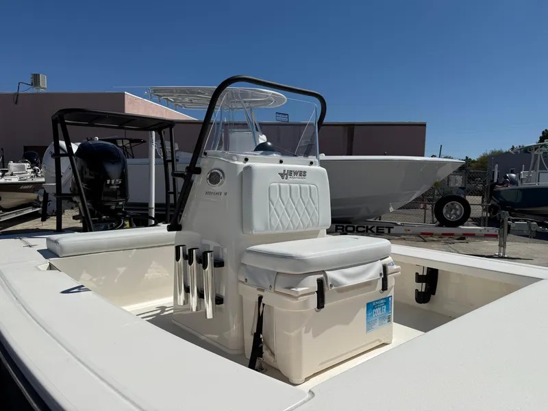 Slide: The Image of 2024 Hewes 18 Redfisher boat with center console and seating, displayed outdoors. - 4