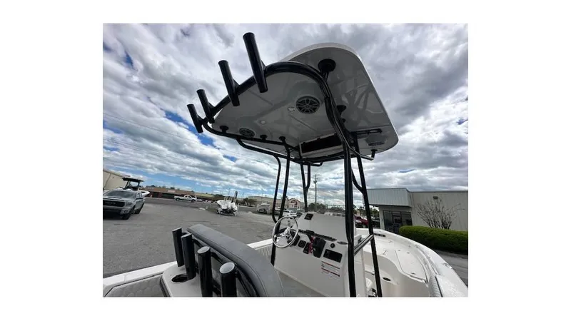 Slide: The Image of 2024 Sea Chaser 23 LX boat with T-top and rod holders under cloudy sky. - 11