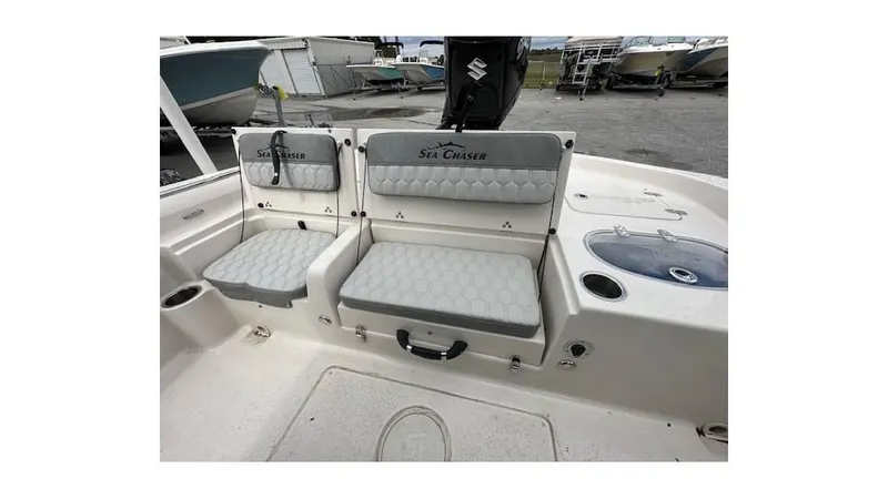 Slide: The Image of 2024 Sea Chaser 23 LX boat interior with cushioned seating and storage compartments. - 6