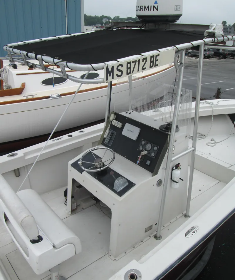 Slide: The Image of 1977 SeaCraft SF 23 IO boat with steering console and canopy in a marina. - 10