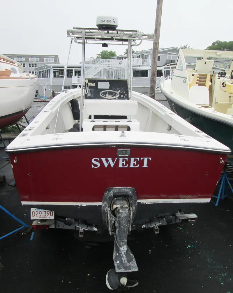 Slide: The Image of 1977 SeaCraft SF 23 IO boat with red hull, named "Sweet," docked in a marina. - 8