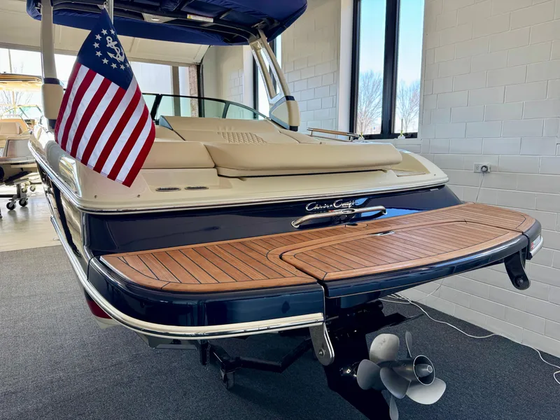 Slide: The Image of 2025 Chris-Craft Sportster 25 boat with American flag, displayed indoors. - 5