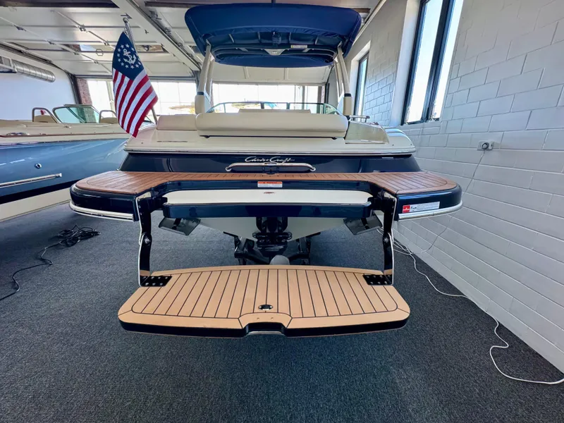 Slide: The Image of 2025 Chris-Craft Sportster 25 boat in showroom, rear view with swim platform. - 8