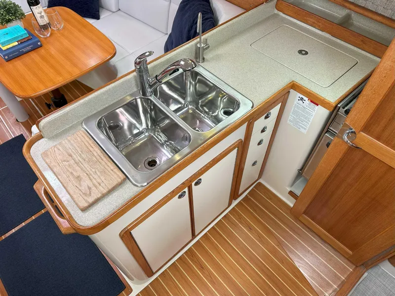 Slide: The Image of 2007 Catalina 34 MkII yacht kitchen with dual sinks and wooden cabinetry. - 13