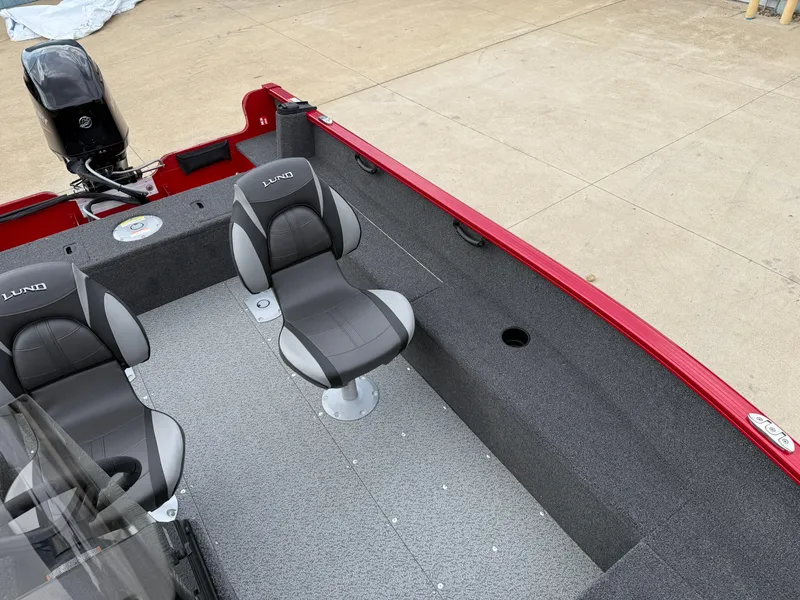 Slide: The Image of 2025 Lund 1650 Rebel XL SS boat interior with gray seating and red exterior. - 11