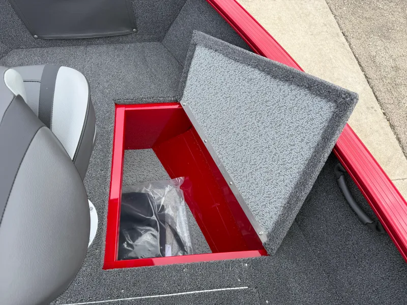 Slide: The Image of 2025 Lund 1650 Rebel XL SS boat storage compartment with open lid, showcasing interior space. - 13