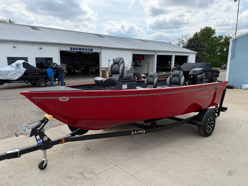 Slide: The Image of 2025 Lund 1650 Rebel XL SS boat in red on a trailer outside a showroom. - 2