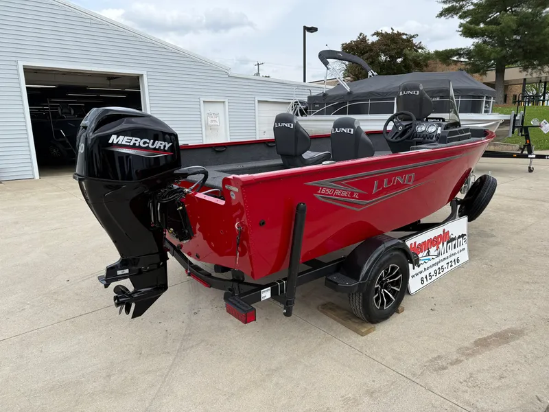 Slide: The Image of 2025 Lund 1650 Rebel XL SS boat with Mercury engine, parked on a trailer. - 6