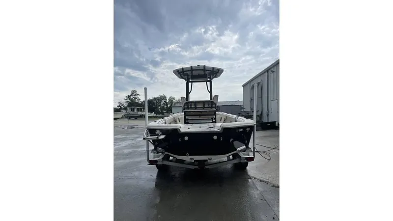 Slide: The Image of 2023 Sea Chaser 23 LX boat on wet pavement under cloudy sky. - 6