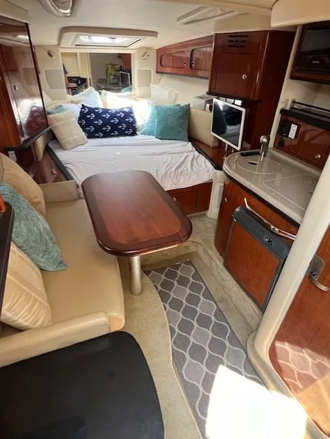 Slide: The Image of Interior of 2007 Sea Ray 290 Sundancer with cozy seating, bed, and kitchenette. - 13