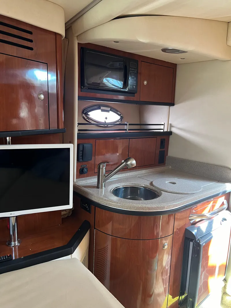 Slide: The Image of 2007 Sea Ray 290 Sundancer interior with kitchenette, sink, and microwave. - 15