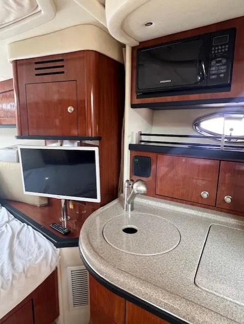 Slide: The Image of 2007 Sea Ray 290 Sundancer interior with kitchenette, TV, and microwave. - 16