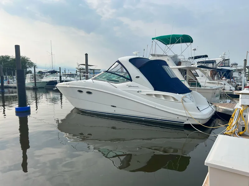 Slide: The Image of 2007 Sea Ray 290 Sundancer docked at marina, calm water, overcast sky. - 2