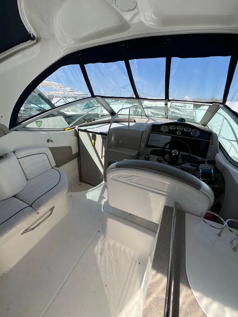 Slide: The Image of 2007 Sea Ray 290 Sundancer cockpit with modern controls and seating, under a clear canopy. - 7
