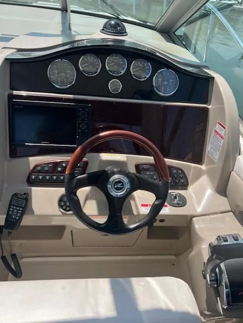 Slide: The Image of 2007 Sea Ray 290 Sundancer helm with gauges, steering wheel, and control panel. - 9