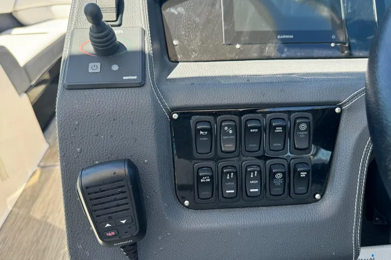 Slide: The Image of Control panel of a 2018 Regal 29 OBX boat with switches and a microphone. - 19