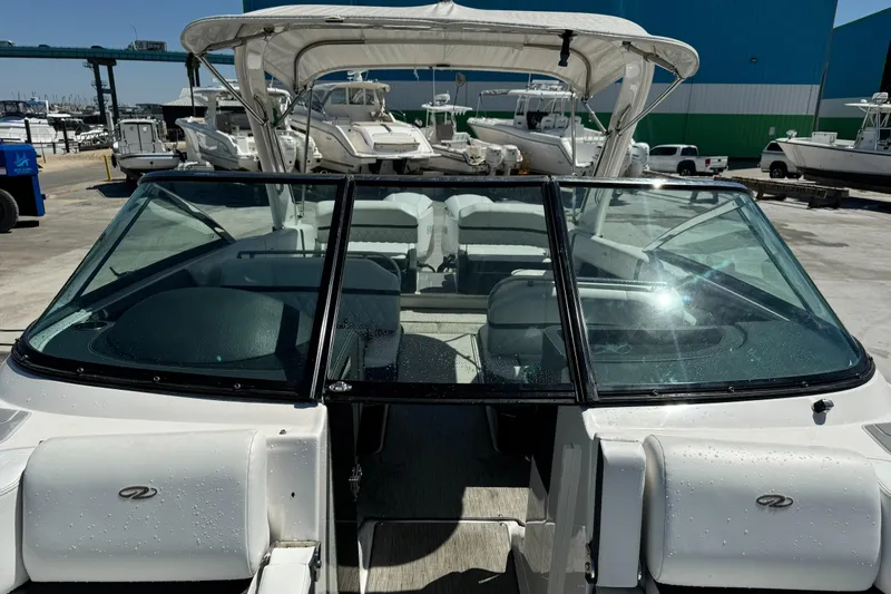 Slide: The Image of 2018 Regal 29 OBX boat with open cockpit and seating, docked at a marina. - 26