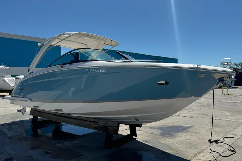 Slide: The Image of 2018 Regal 29 OBX boat on a stand, blue hull, sunny day. - 28