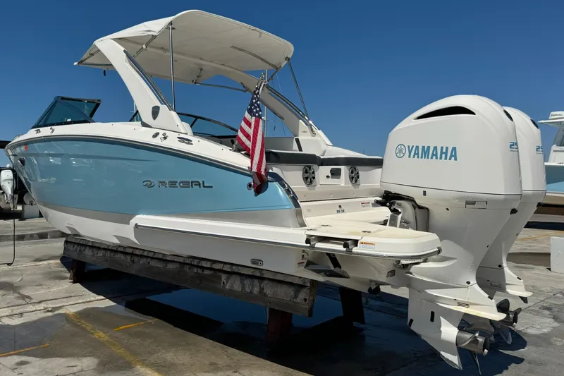 Slide: The Image of 2018 Regal 29 OBX boat with Yamaha engine, docked, featuring American flag. - 30