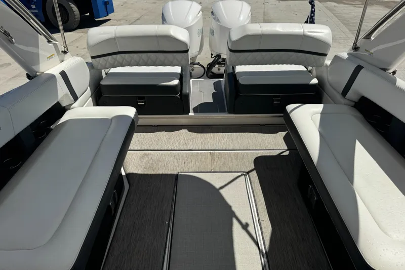 Slide: The Image of 2018 Regal 29 OBX boat interior with white seating and twin outboard engines. - 4
