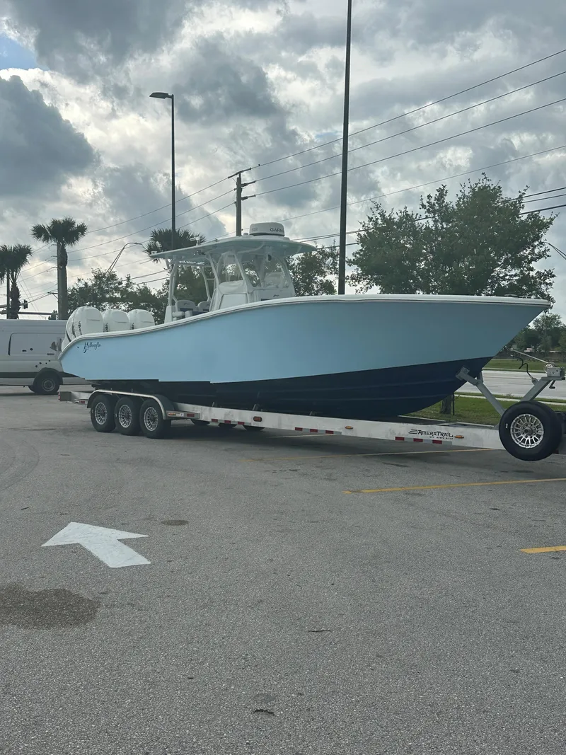 Slide: The Image of 2019 Yellowfin 34 Center Console boat on trailer, parked outdoors under cloudy sky. - 38
