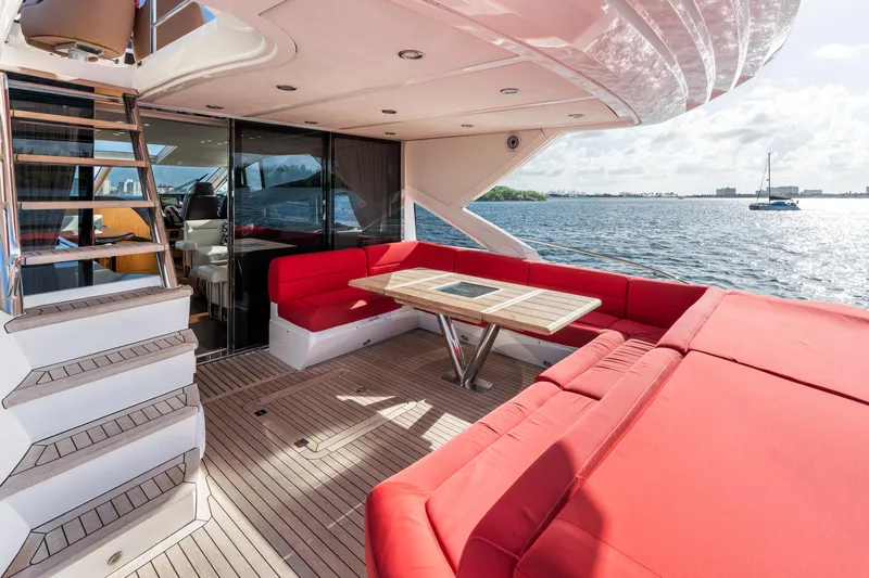 Slide: The Image of 2014 Sunseeker 68 Sport Yacht with red seating, wooden deck, and ocean view. - 32