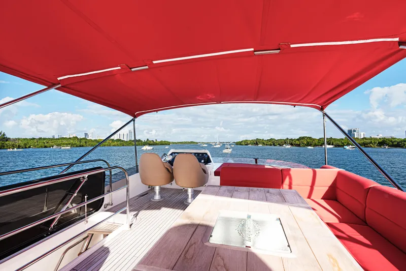 Slide: The Image of 2014 Sunseeker 68 Sport Yacht with red canopy, spacious deck, and scenic water view. - 41