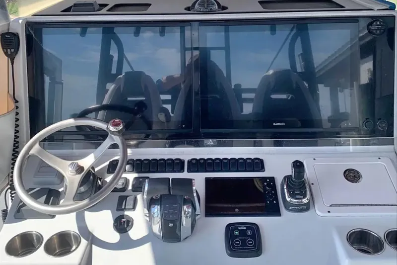 Slide: The Image of 2018 Freeman 42LR boat dashboard with steering wheel, controls, and dual Garmin screens. - 11