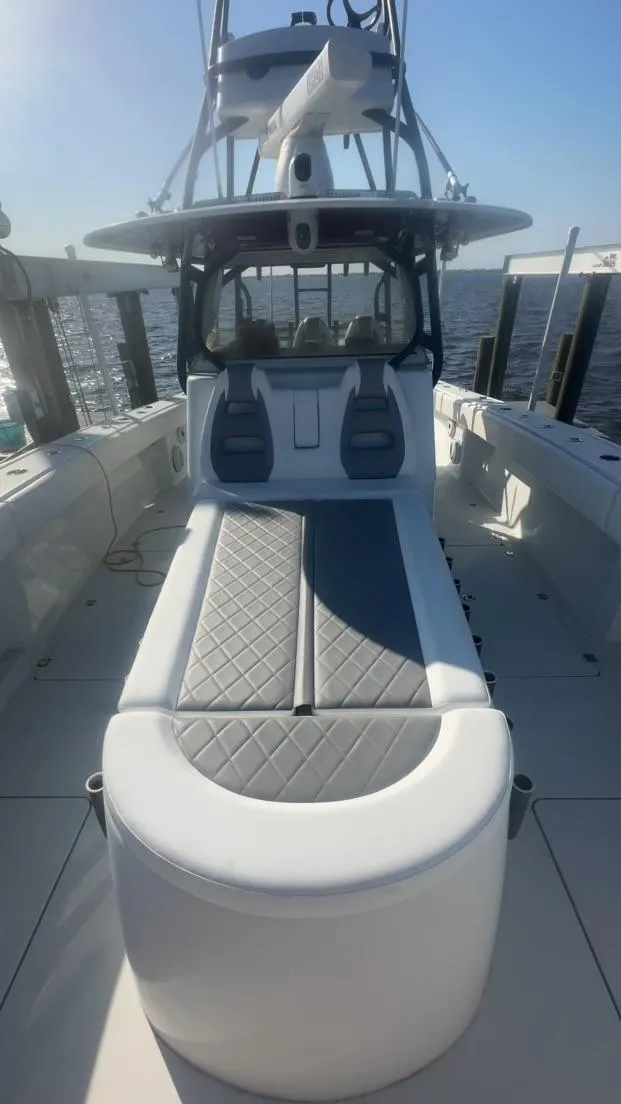 Slide: The Image of 2018 Freeman 42LR boat with cushioned seating, docked by the water. - 12