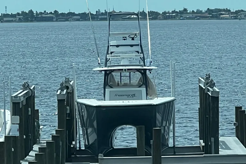 Slide: The Image of Freeman 42LR 2018 boat docked on calm water with distant shoreline. - 7