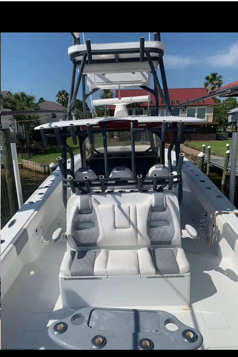 Slide: The Image of 2018 Freeman 42LR boat with dual seating and sleek design, docked near waterfront homes. - 8