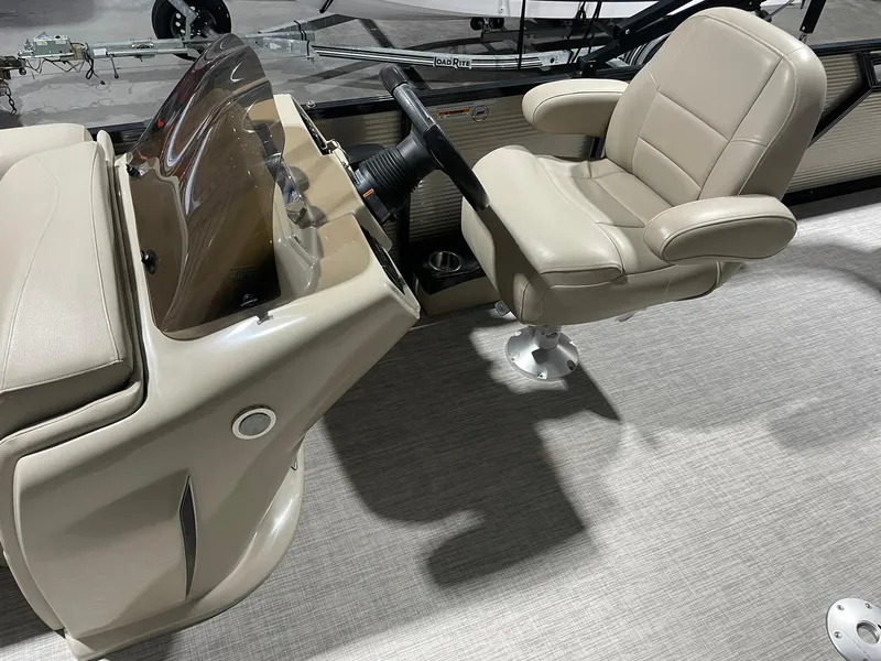 Slide: The Image of 2019 Avalon Lsz Rear Fish boat interior with beige captain's chair and steering console. - 10