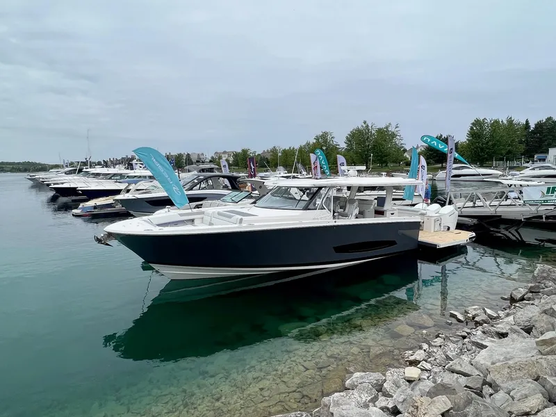 The Image of 2026 Regal 50 SAV yacht docked in a marina, surrounded by other boats. - 0